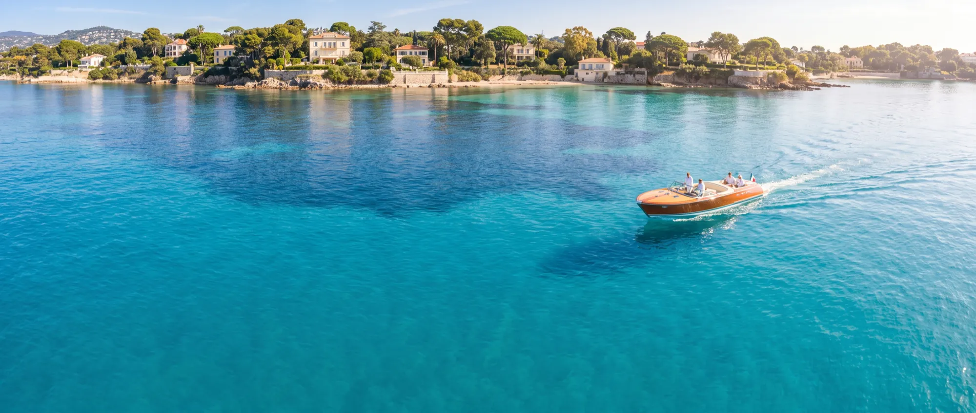 A day boat alone on turquoise water off Cap Ferrat in the middle of the day.