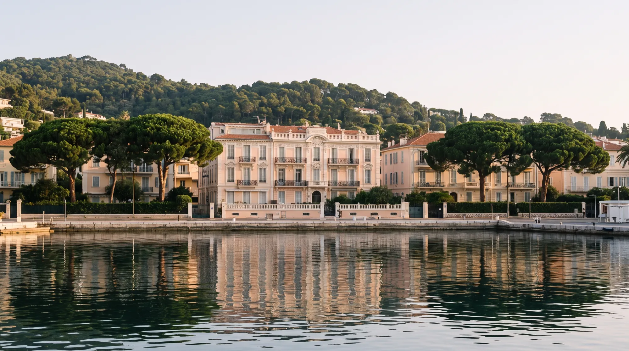 The sheltered harbour at Beaulieu-sur-Mer at first light, Cap Ferrat rising behind it.