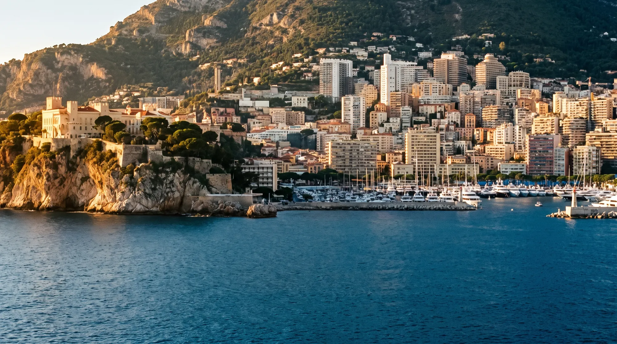 Monaco from the sea in late afternoon, the Rock and the towers of Monte-Carlo behind the harbour.