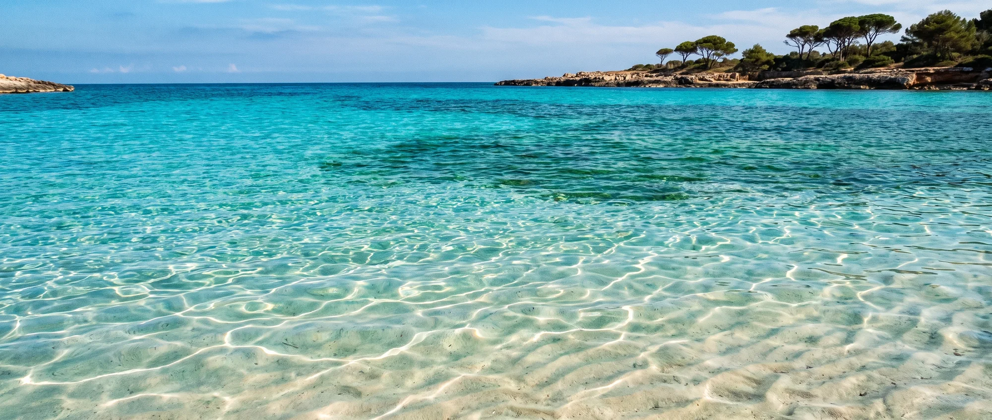 Shallow water over pale sand, the bottom visible right through it.